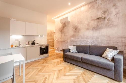 Una sala de estar con un sofá y una cocina. en Calzolerie Luxury Apartment, en Bolonia