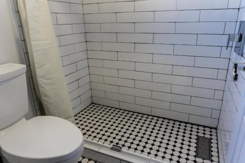 a bathroom with a toilet and a tiled shower at Downtown Phoenix Hotel in Phoenix