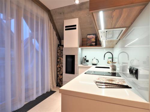 a kitchen with white counters and a stove top oven at VIP Apartamenty Gorska Odskocznia SPA in Zakopane