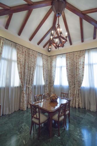 a dining room with a table and chairs and curtains at LA ATALAYA GREAT LUXURY ATTIC in Antequera