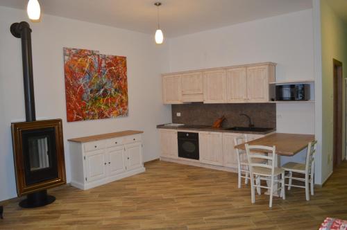 una cucina con armadi bianchi, tavolo e sedie di Parravicini Red Flower apartment a Tirano