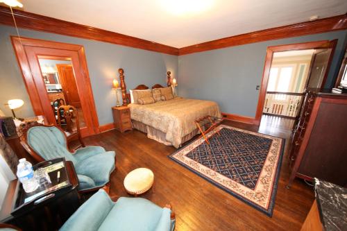 a bedroom with a bed and a couch and a chair at Leonard at Logan House in Grand Rapids