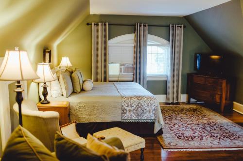a bedroom with a bed and a chair and a window at Leonard at Logan House in Grand Rapids