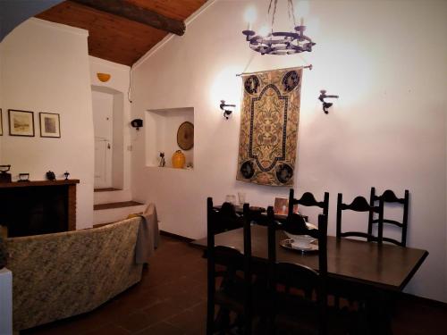 a dining room with a table and a clock on the wall at Casa das 3 Palmeiras in Arraiolos