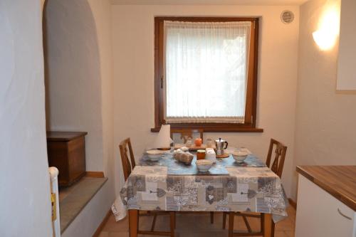a dining room with a table with chairs and a window at Alle pendici del Monte Rosa in Champoluc