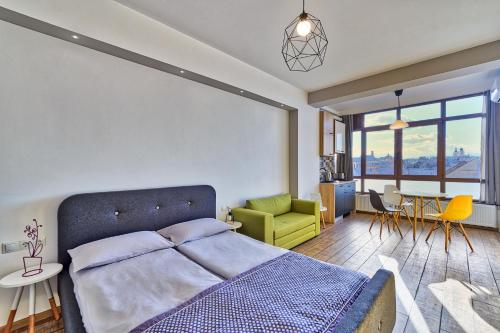 Un dormitorio con una cama y una mesa y sillas. en Panorama studio, en Sibiu