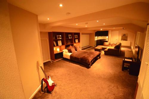 a large living room with a bed and a guitar at Aparthotel Glovers Court in Preston