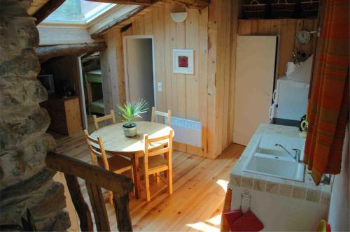 eine Küche und ein Esszimmer mit einem Tisch und einem Waschbecken in der Unterkunft Arcogite in Vicdessos