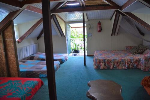 a room with two beds and a chair in it at Fare Maheata in Pihaena