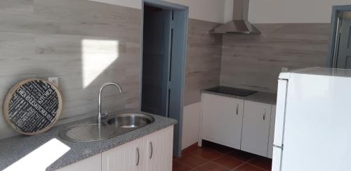 a kitchen with a sink and a white refrigerator at Casa Azul in Avis