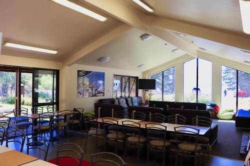 a room with chairs and a couch and tables at Lakes Edge Lodge in Lake Tekapo