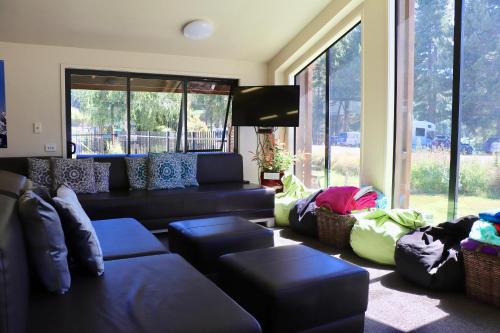 a living room with couches and a large window at Lakes Edge Lodge in Lake Tekapo