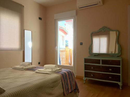 ピノス・ヘニルにあるDúplex del Ríoのベッドルーム1室(ベッド1台、鏡、ドレッサー付)