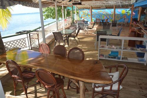 a wooden table and chairs on the deck of a restaurant at Fare Maheata in Pihaena