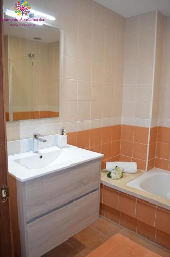a bathroom with a sink and a tub and a mirror at MARINA AZUL GOLF in Ayamonte