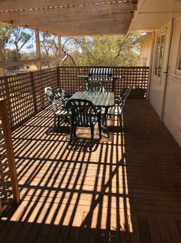 a patio with a table and chairs on a deck at Home away from home in Merredin