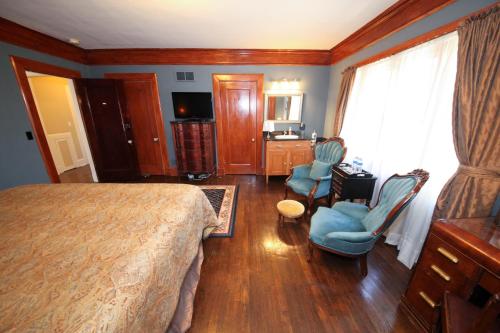 a bedroom with a bed and two chairs and a desk at Leonard at Logan House in Grand Rapids