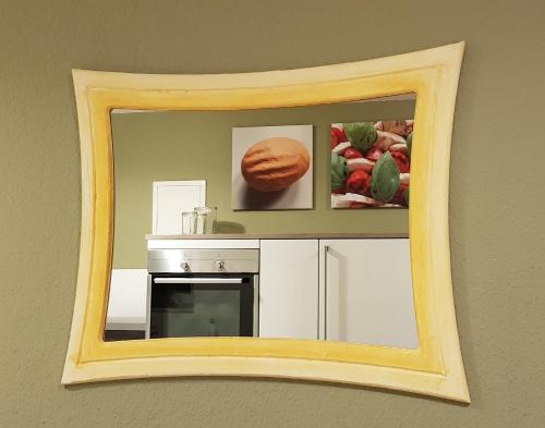 a mirror on a wall with pictures of fruits and vegetables at Deluxapartment in Kaiserslautern