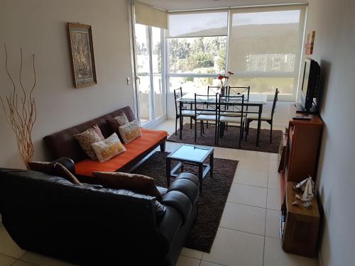un soggiorno con 2 divani e una sala da pranzo di Departamento en Lomas de Papudo II a Papudo