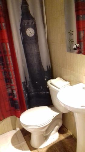 a bathroom with a toilet and a sink and big ben at Casa Turismo Puerto Montt in Puerto Montt