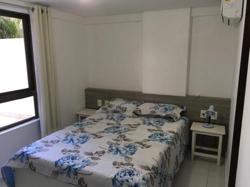 Un dormitorio con una cama con flores azules. en Praia do Cabo Branco RV, en João Pessoa