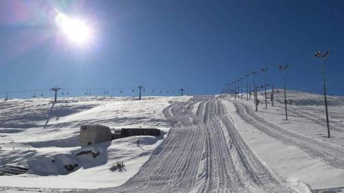 a snow covered road with tracks in the snow at Villa 99 in Popova Shapka