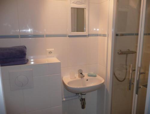 a white bathroom with a sink and a shower at Chambre d'Hotes Pause en Chemin in Condette