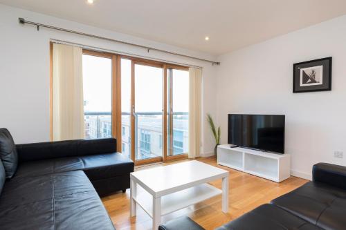 a living room with a couch and a tv at East Croydon Apartments - Just 3 mins walk to East Croydon station in Croydon