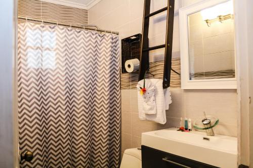 a bathroom with a shower curtain and a sink at Palm Spring Inn in Oranjestad