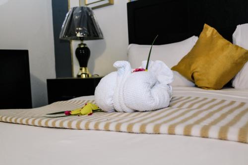 a stuffed animal is sitting on a bed at Palm Spring Inn in Oranjestad