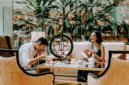 a man and woman sitting at a table in a restaurant at Shangri-La Kuala Lumpur in Kuala Lumpur