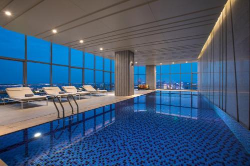 a swimming pool in a building with a view at Ascott Harmony City Nantong in Nantong