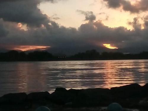 a sunset over a body of water with clouds at Kanalu Studio in Bouillante