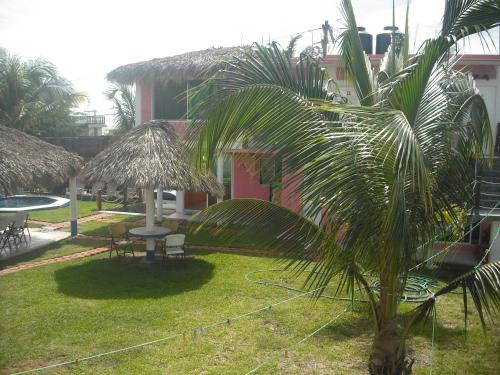 a yard with a palm tree and a table and chairs at Hotel Villas del Rey in Chachalacas
