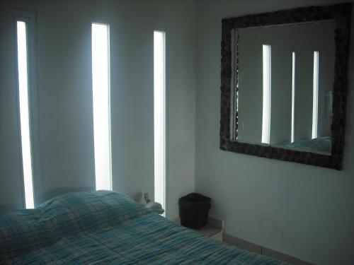 a bedroom with a bed and a mirror on the wall at Hotel Villas del Rey in Chachalacas