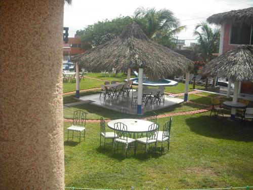 a group of tables with chairs and umbrellas at Hotel Villas del Rey in Chachalacas