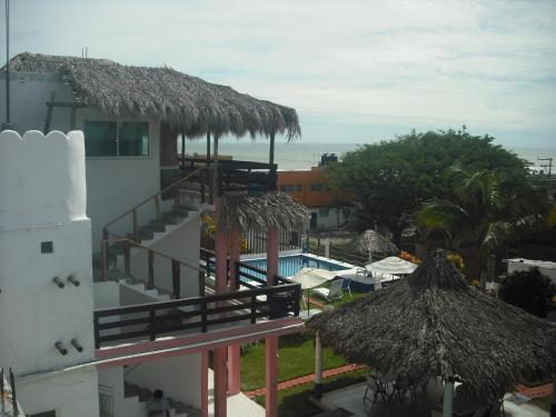 a view of a resort with a swimming pool and a building at Hotel Villas del Rey in Chachalacas