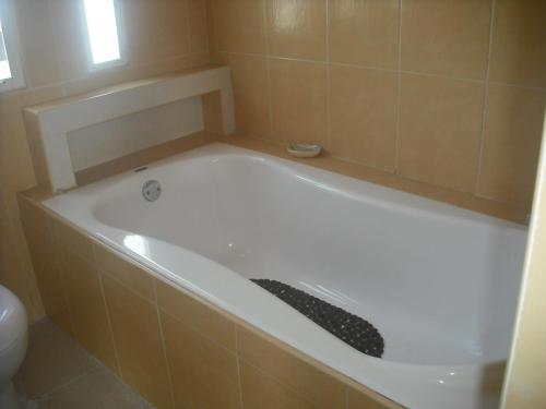 a white bath tub in a tiled bathroom at Hotel Villas del Rey in Chachalacas
