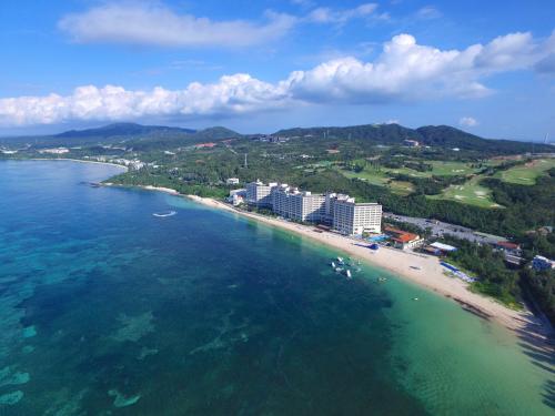 an aerial view of a beach with buildings and the ocean at Rizzan Sea Park Hotel Tancha Bay in Onna