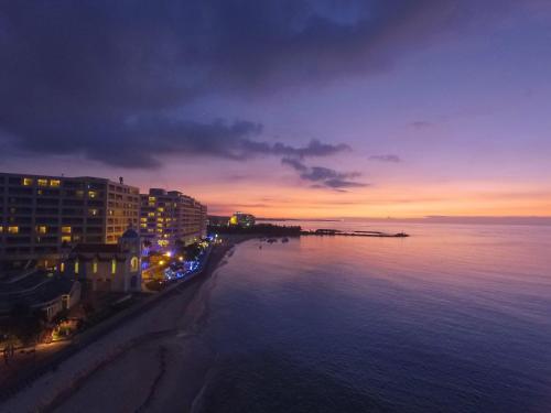 Rizzan Sea Park Hotel Tancha Bay في أونا: اطلالة على المدينة ليلا مع الماء