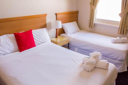 um quarto de hotel com duas camas com toalhas em Gardners Inn Hotel em Blackheath