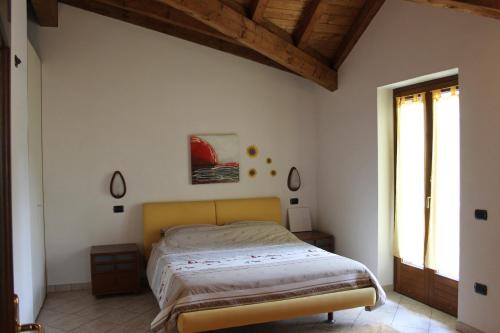 Schlafzimmer mit einem Bett mit Holzdecke in der Unterkunft Villetta Nembra in Edolo