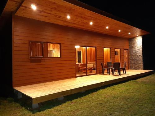a cabin with a wooden deck at night at Paraíso Liumalla Lodge in Villarrica