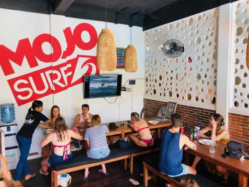 a group of people sitting at a table in a restaurant at Mojosurf Camp Canggu in Canggu