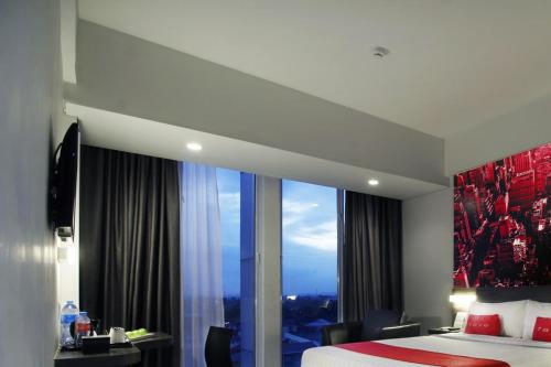 a hotel room with a bed and a large window at favehotel Pekanbaru in Pekanbaru