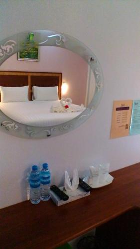 a bedroom with a bed with a mirror on the wall at Tong Chang Resort in Chumphon
