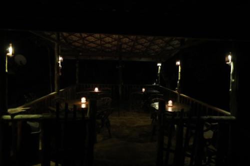 a room with a table with candles in the dark at Sinharaja Forest Edge in Deniyaya