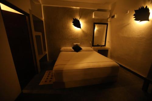 a small room with a bed and a mirror at Sinharaja Forest Edge in Deniyaya