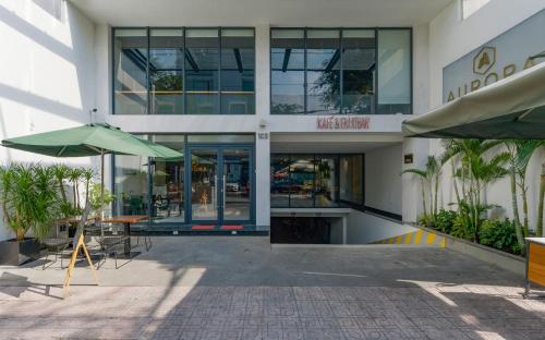 a building with a courtyard with tables and an umbrella at Aurora Serviced Apartments in Ho Chi Minh City