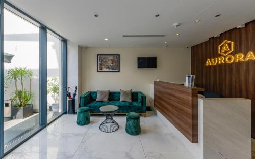 a lobby with a green couch and a table at Aurora Serviced Apartments in Ho Chi Minh City
